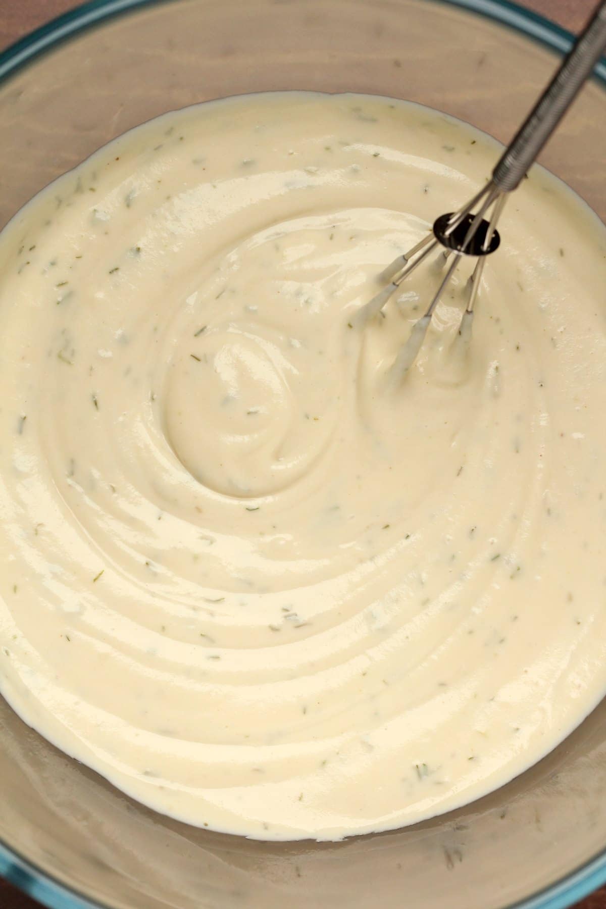 Vegan cream cheese in a bowl with a whisk.