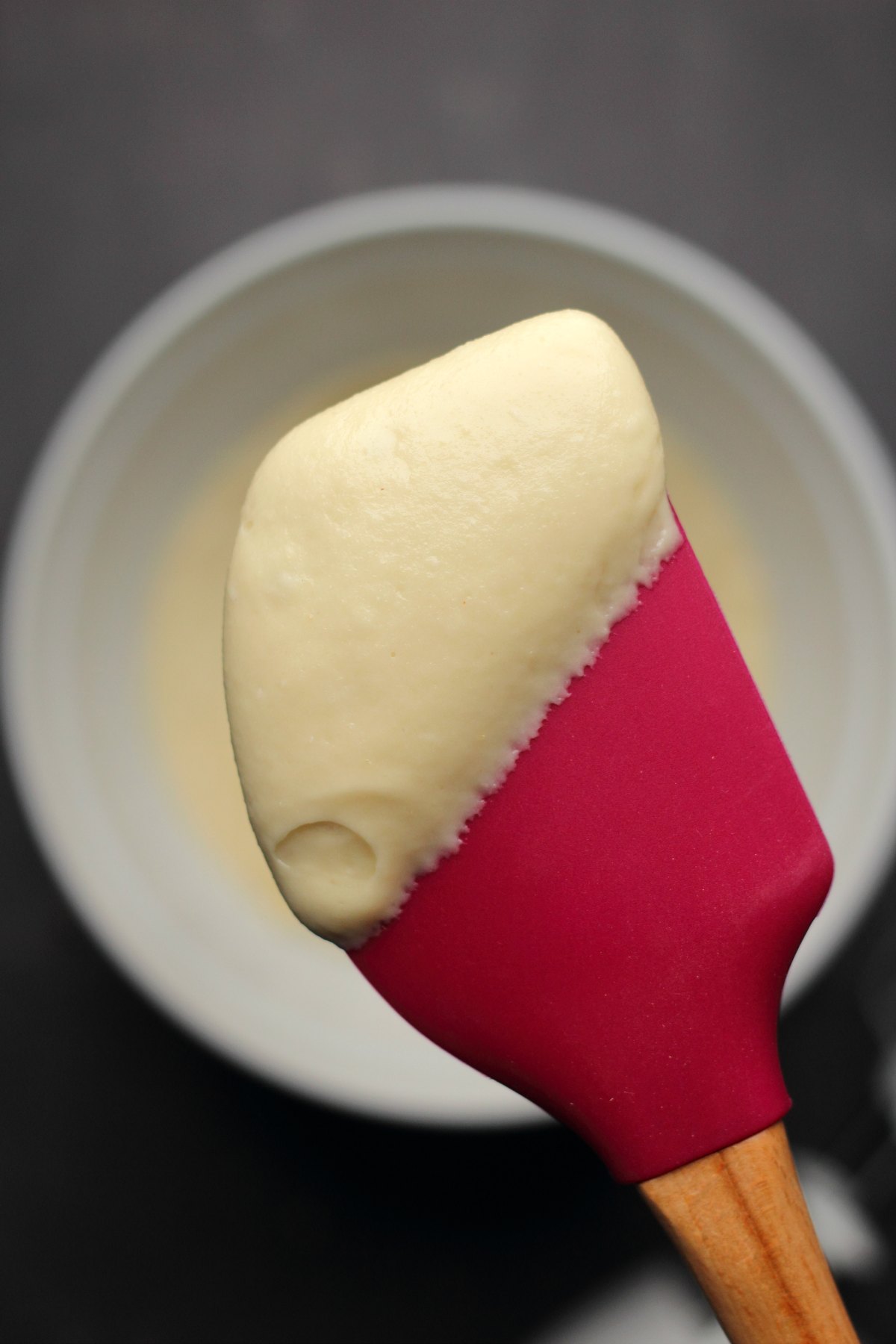 Vegan cream cheese frosting on a red spatula. 