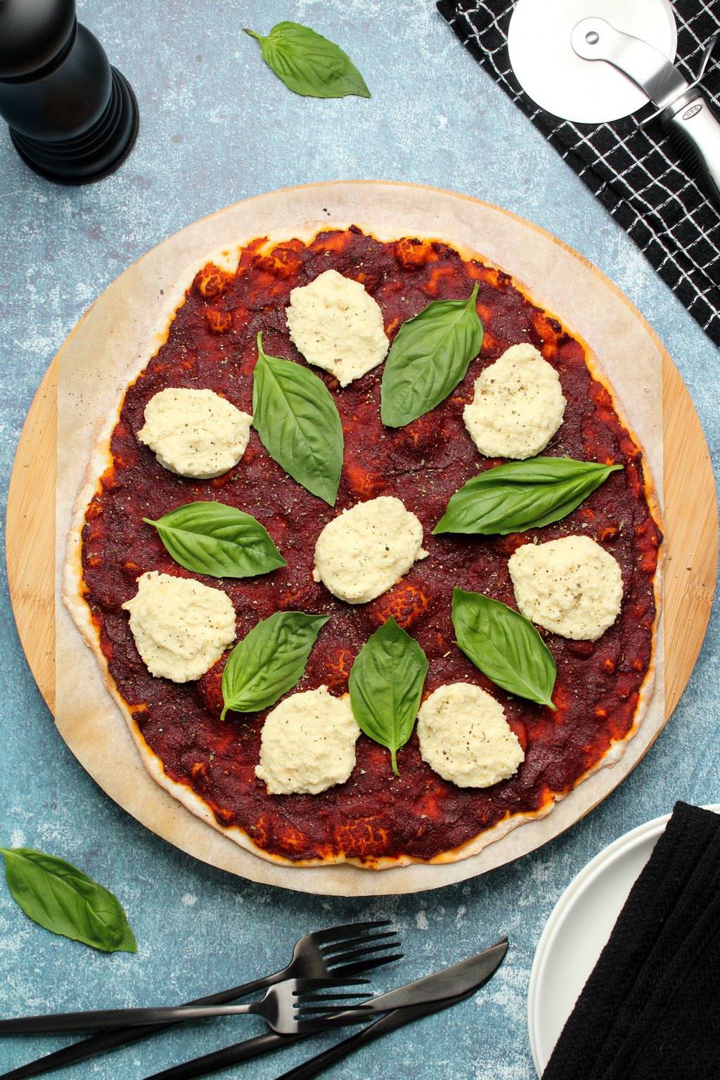 Vegan pizza topped with fresh basil and vegan ricotta. 