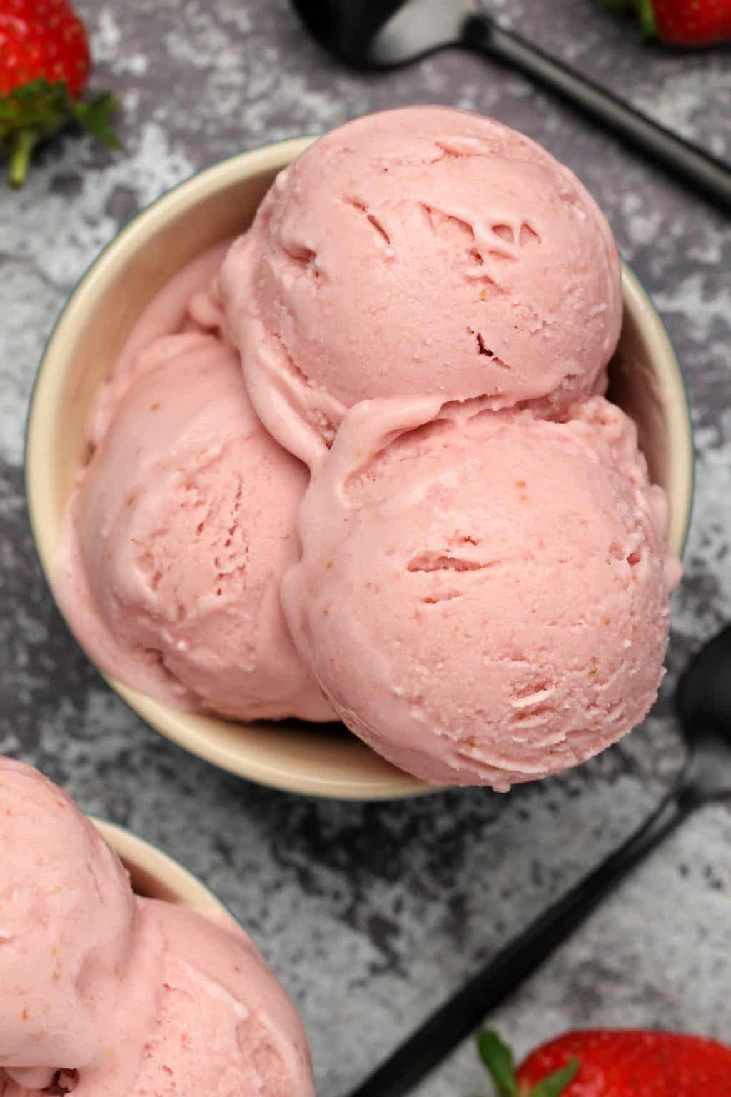 Scoops of vegan strawberry ice cream in a bowl. 