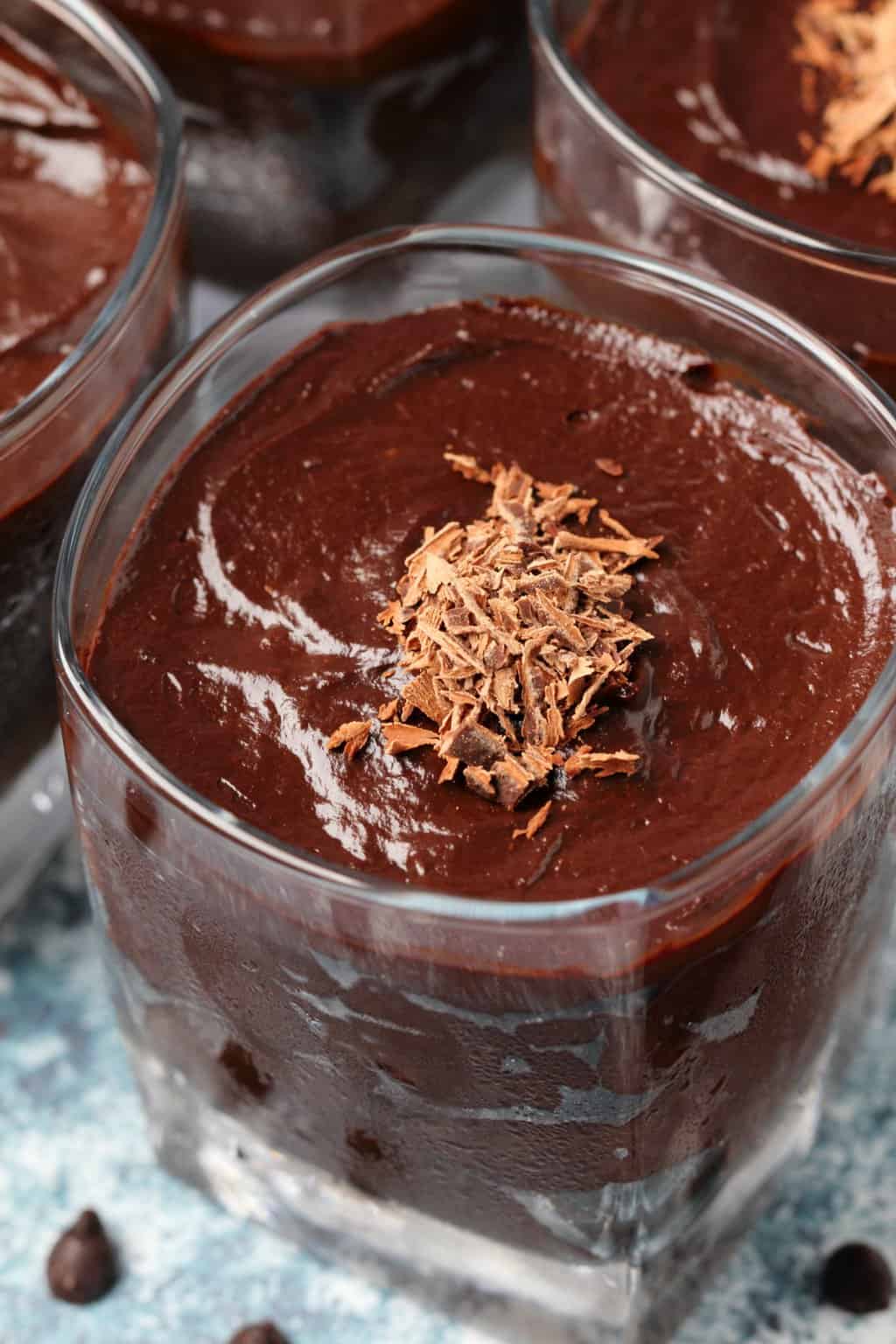 Vegan avocado chocolate mousse topped with chocolate flakes in a glass. 