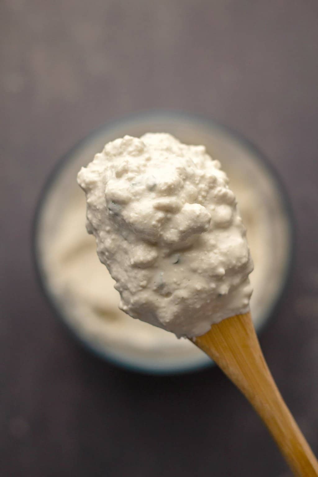 Vegan cottage cheese on a wooden spoon. 