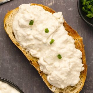 Vegan cottage cheese spread on a piece of toasted bread.