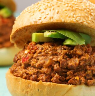 Vegan sloppy joes topped with avocado slices and fresh basil.