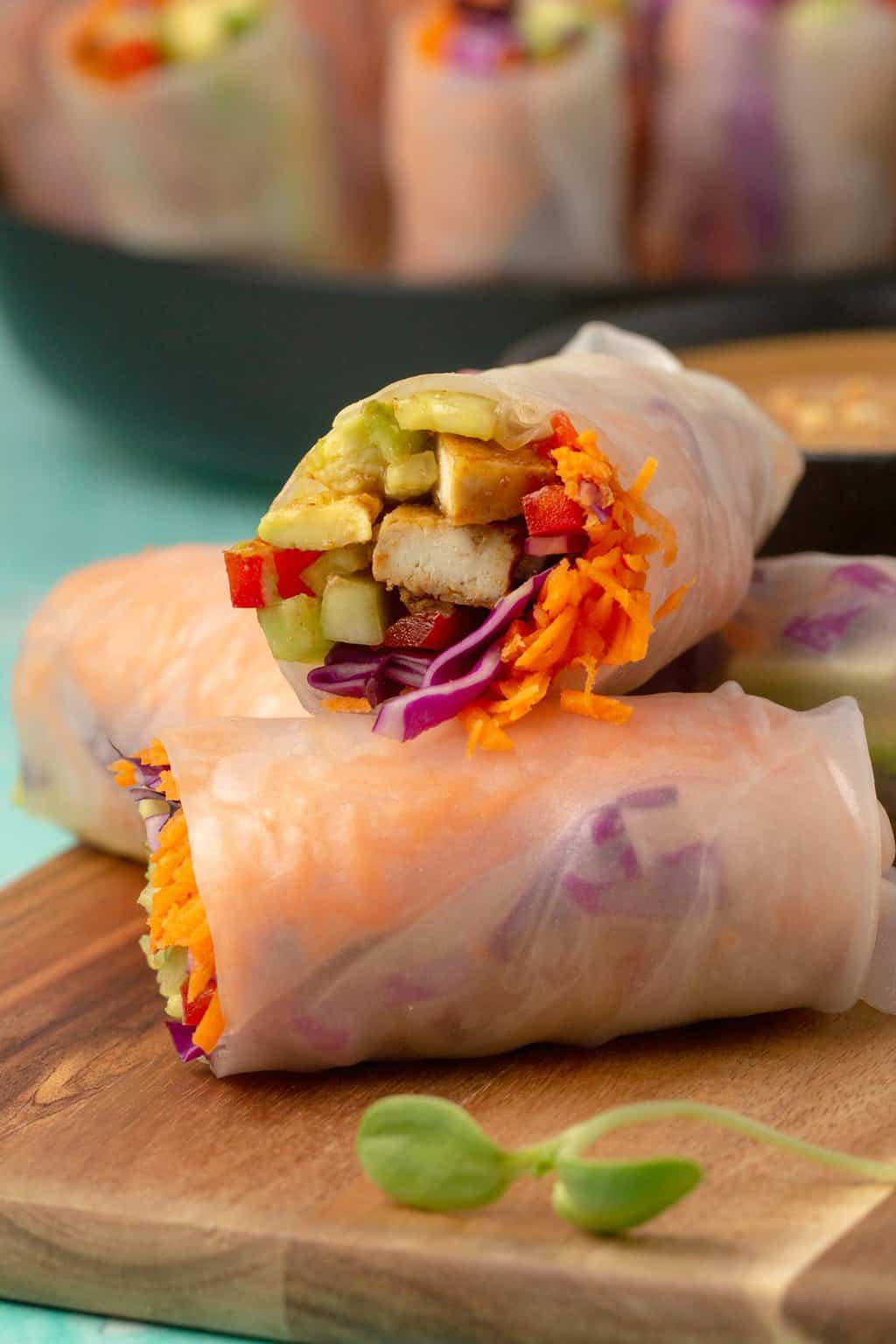 Vegan summer rolls with tofu and veggies on a wooden board. 