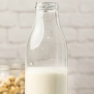 Cashew milk in a glass milk bottle.