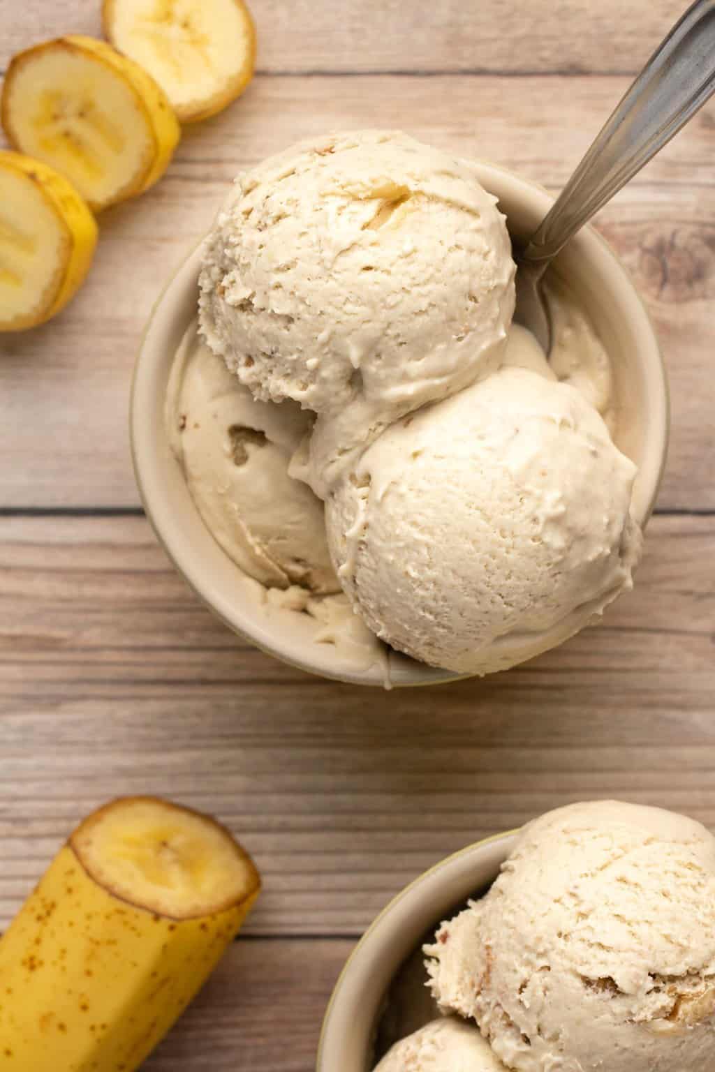 Scoops of vegan banana ice cream in a bowl with a spoon. 