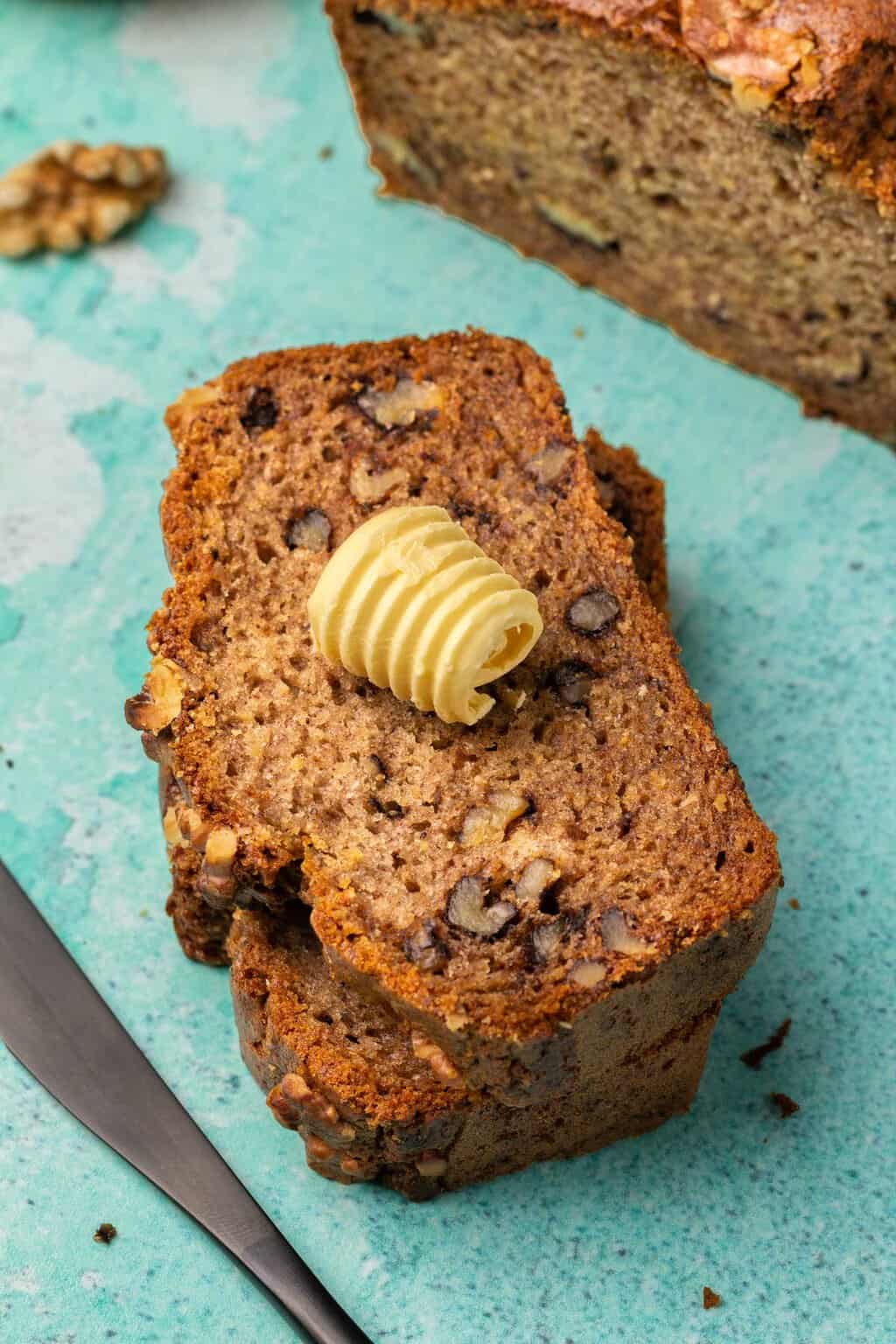 Slices of vegan gluten free banana bread with a knob of butter on top. 