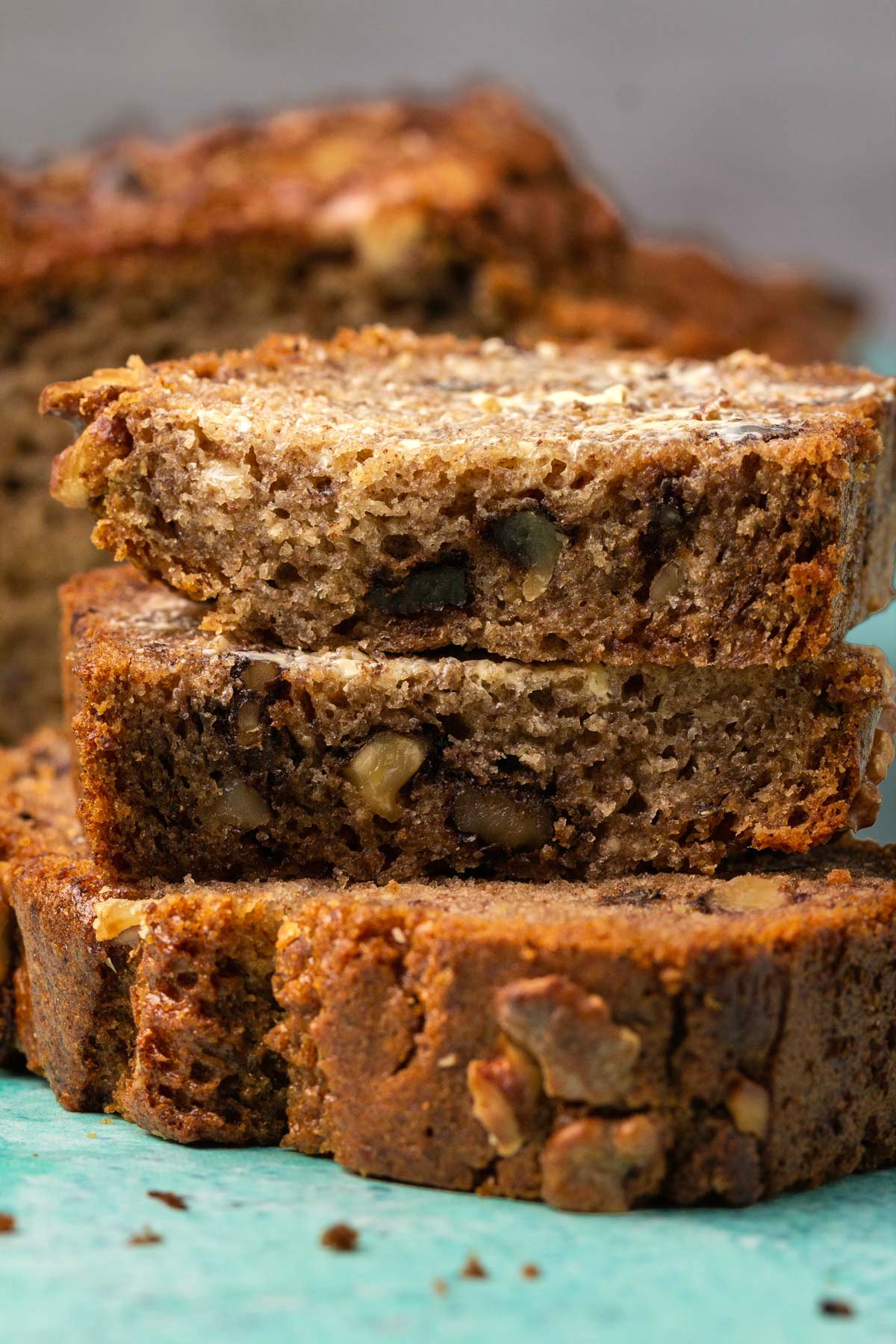 Slices of buttered vegan gluten free banana bread in a stack. 