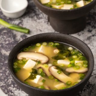 Vegan miso soup in black bowls.