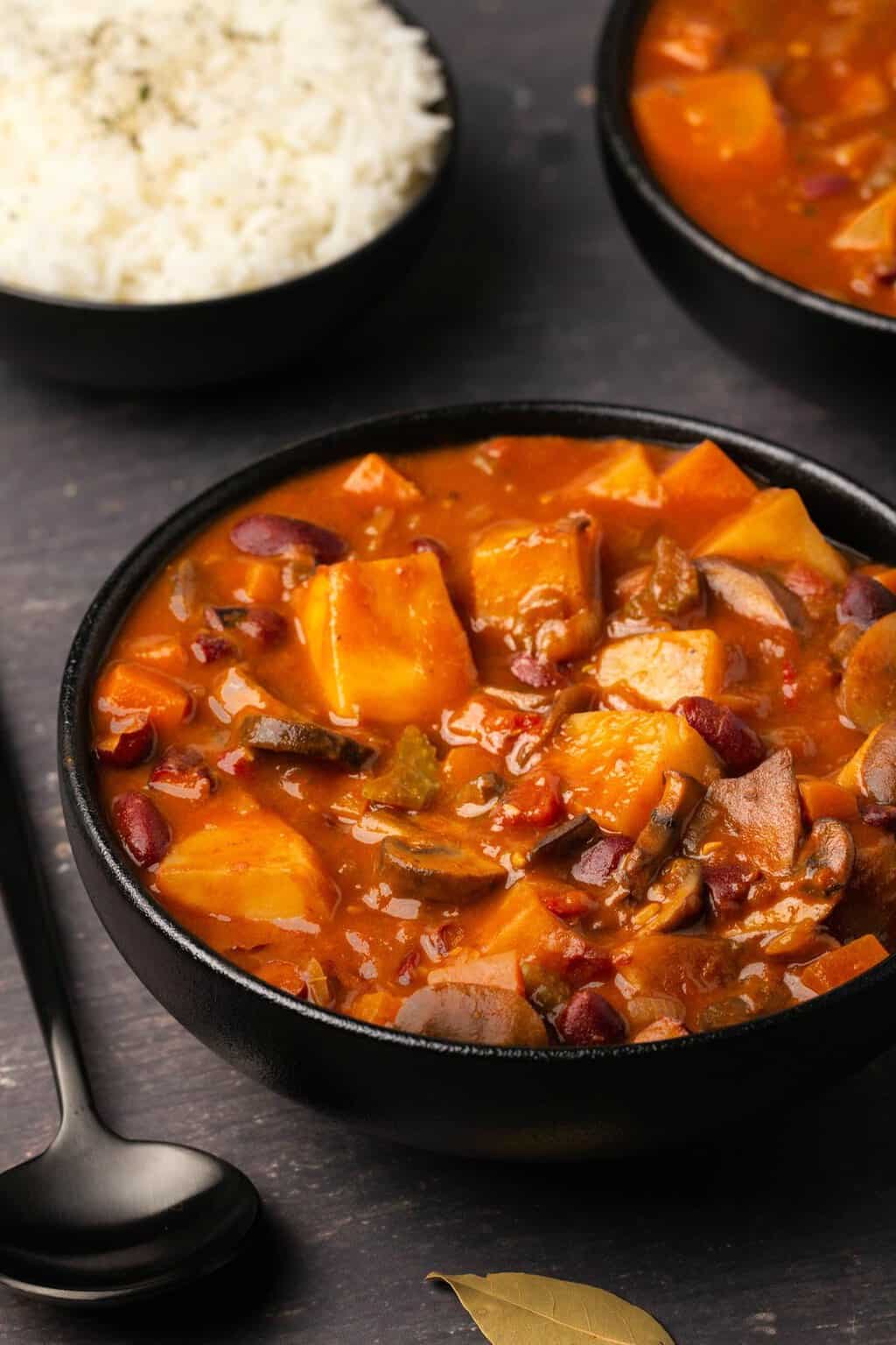 Vegan stew in a black bowl. 