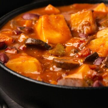 Vegan stew in a black bowl.