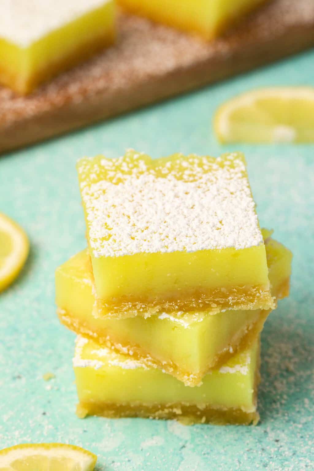 Vegan lemon bars in an uneven stack. 
