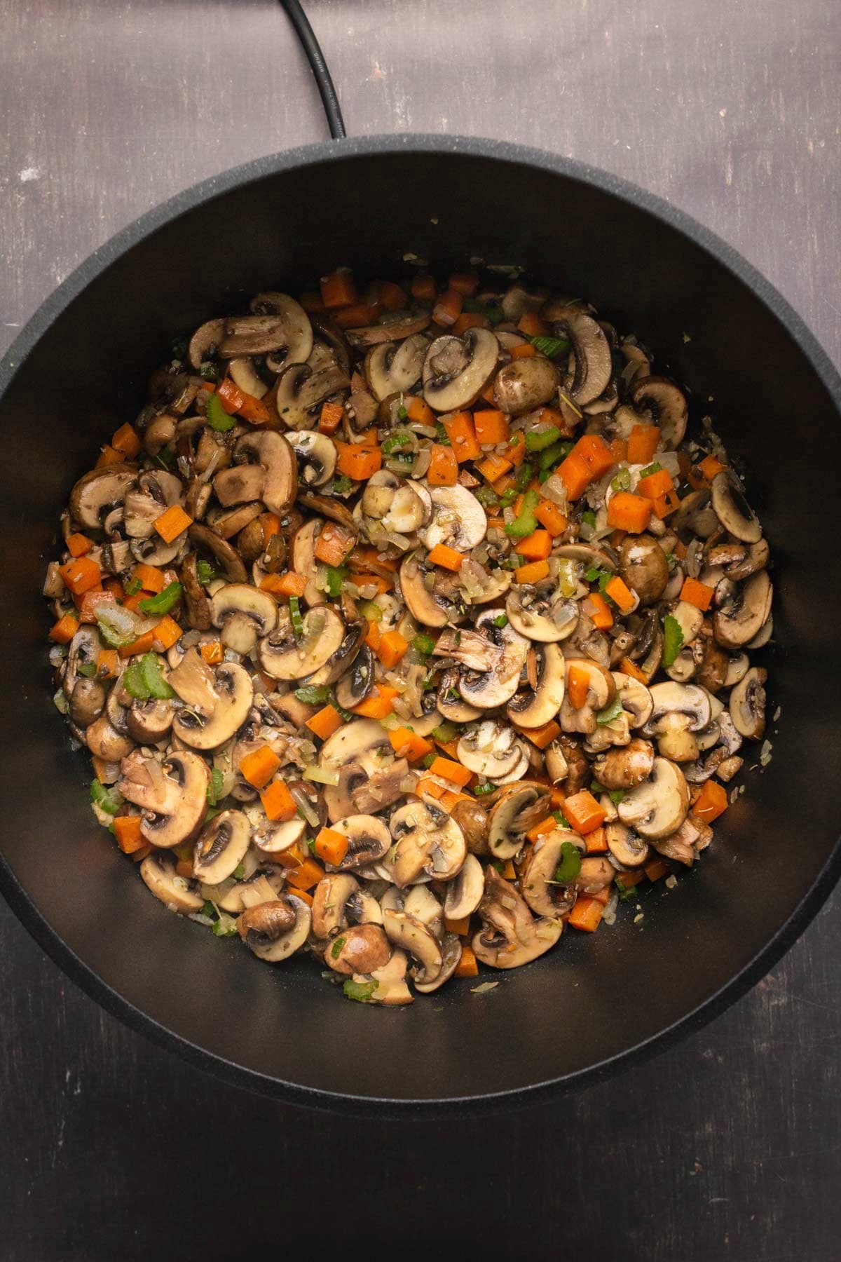 Photo of mushrooms and veggies in a pot.