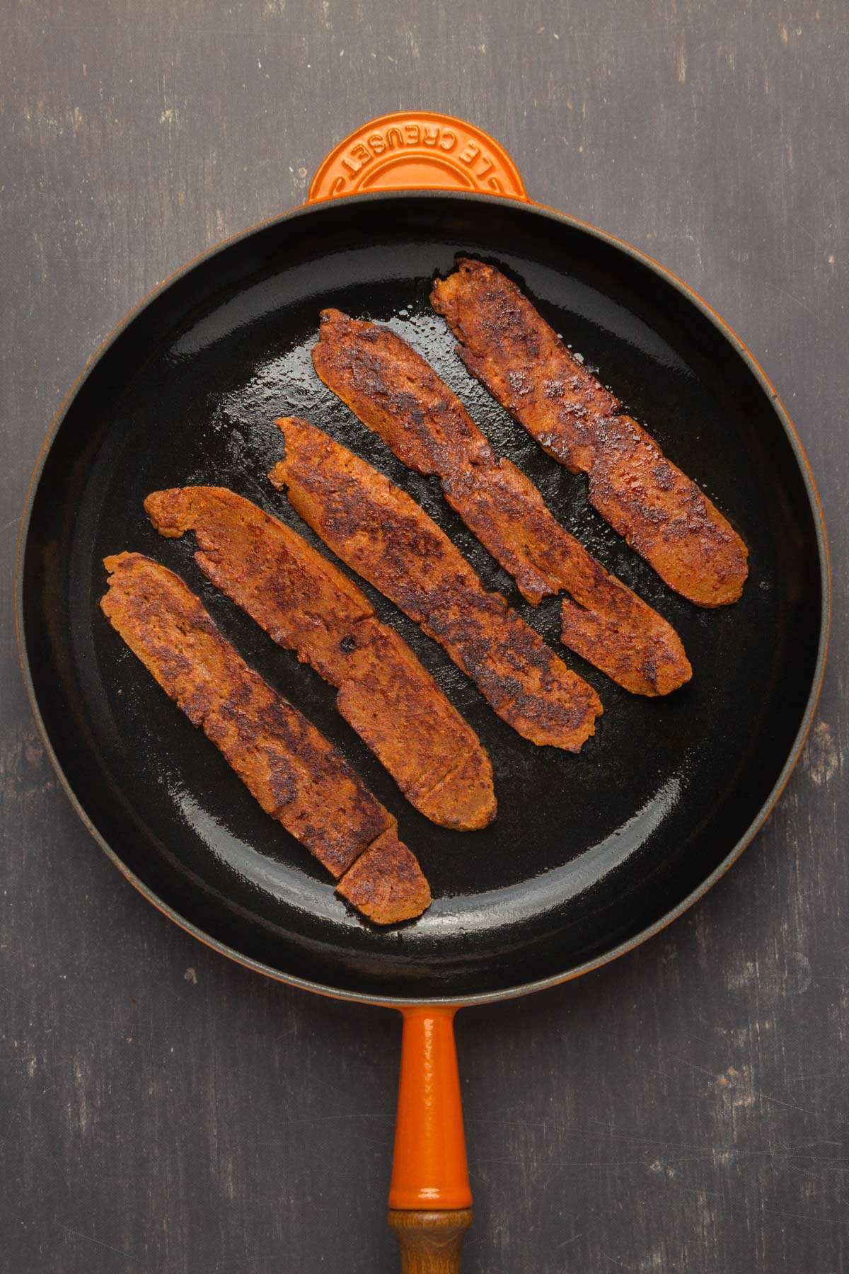 Vegan bacon in a frying pan.