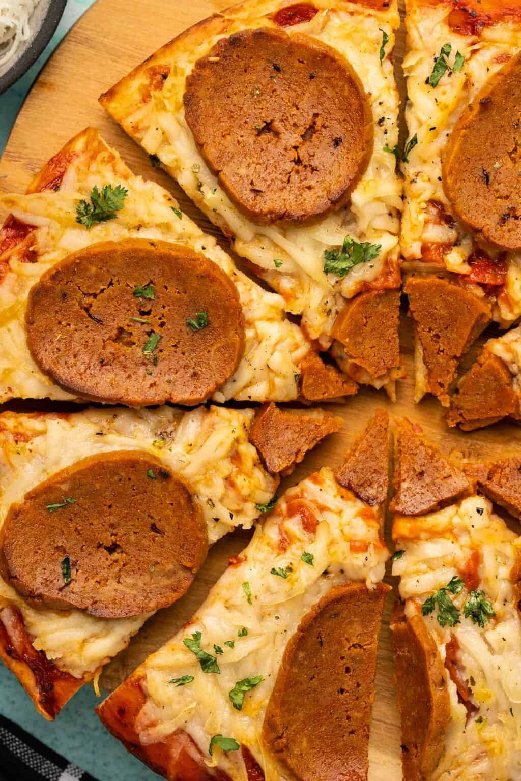 Vegan pepperoni on a sliced pizza. 