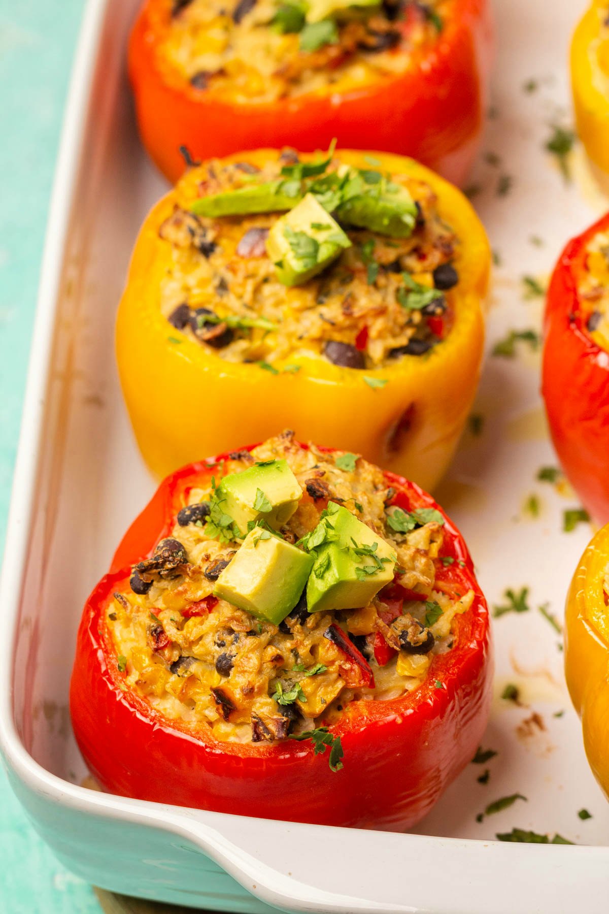 Vegan stuffed peppers in a white dish. 