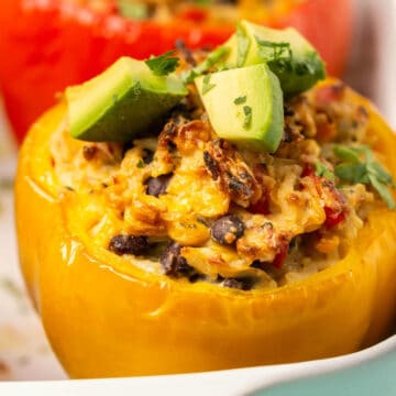Vegan stuffed peppers in a white baking dish.
