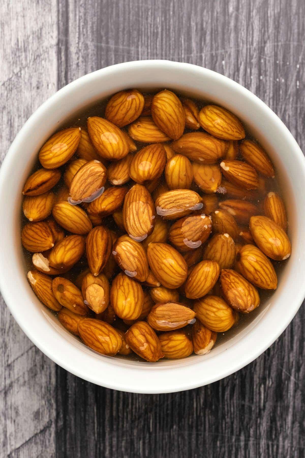 Almonds soaking in water in a bowl. 