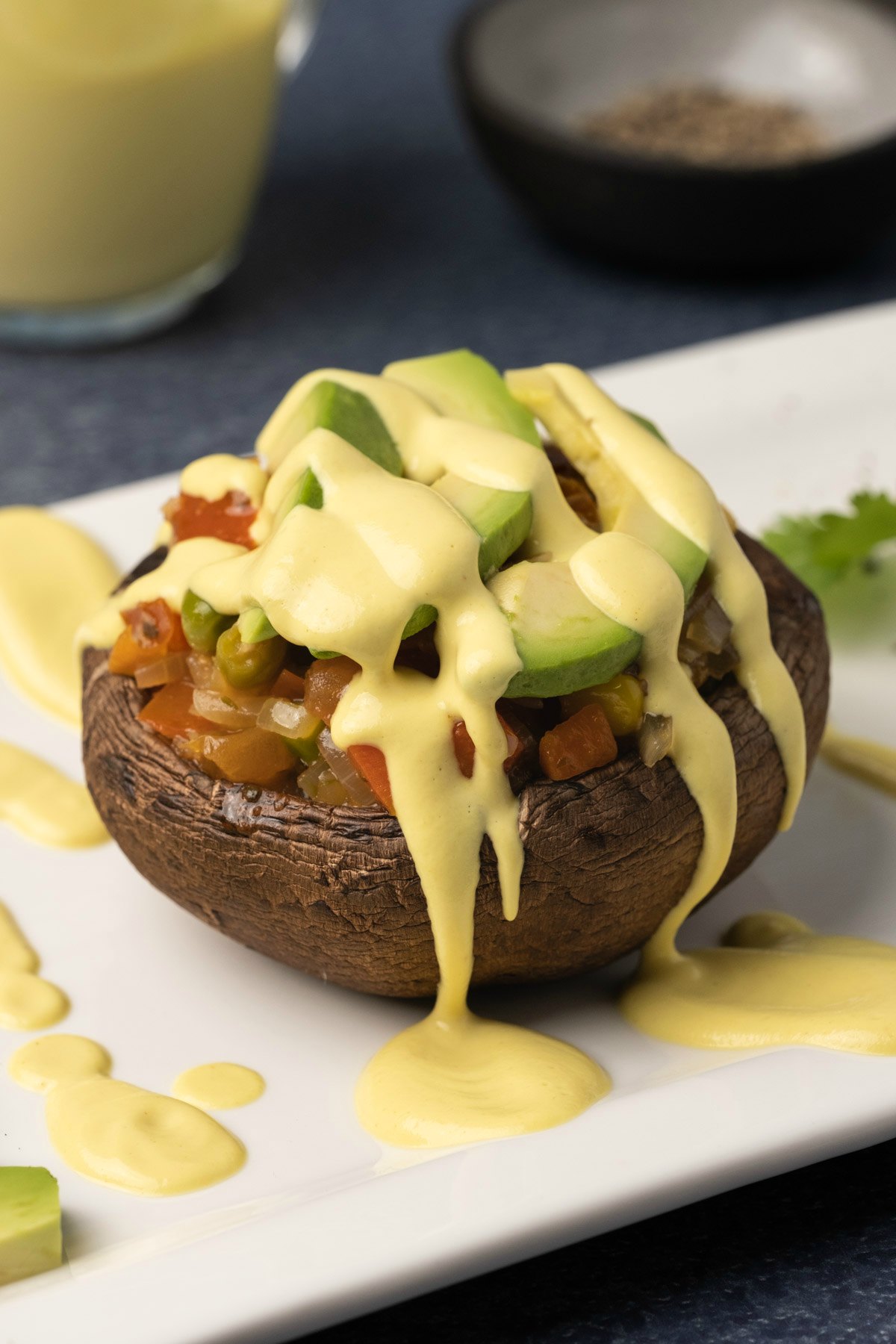 Vegan hollandaise sauce drizzled over a roasted mushroom and veggie stack. 