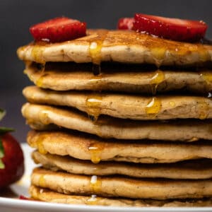 Vegan protein pancakes stacked up on a white plate.