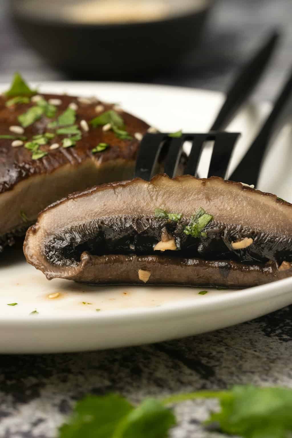 Sliced portobello mushroom on a plate with a fork. 