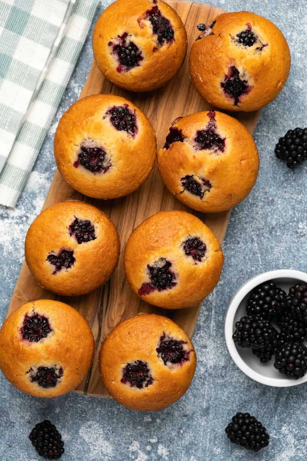 Vegan blackberry muffins on a wooden board. 