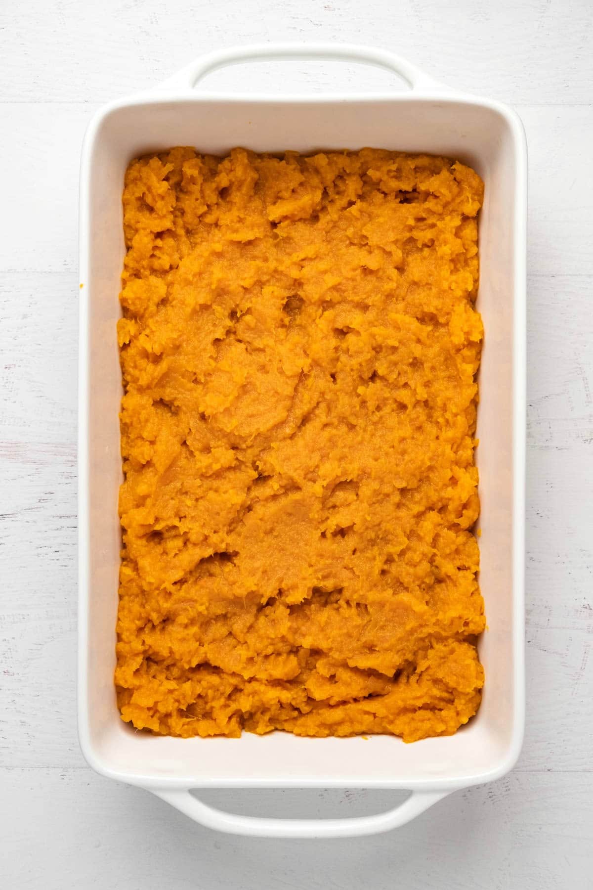 Mashed sweet potato in a white dish.