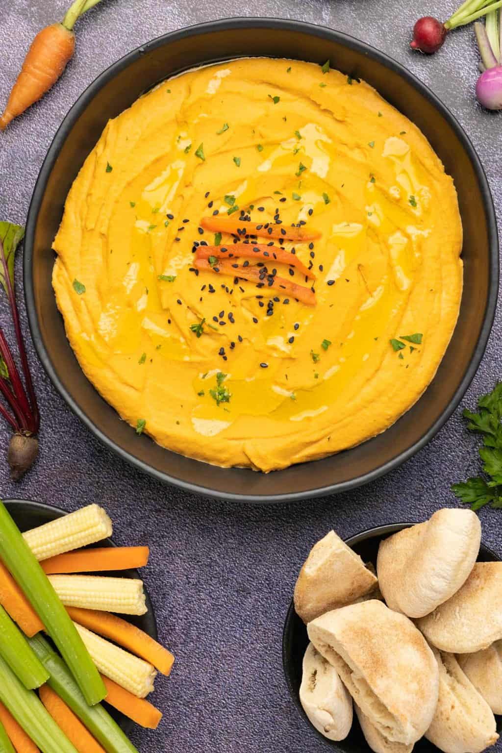 Roasted red pepper hummus in a black bowl. 