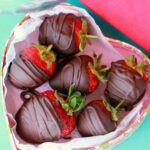 Vegan chocolate covered strawberries in a heart shaped box.