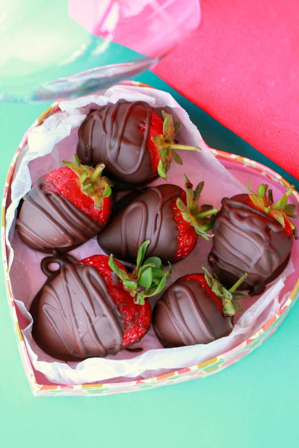  Vegane Erdbeeren mit Schokoladenüberzug in einer herzförmigen Schachtel.
