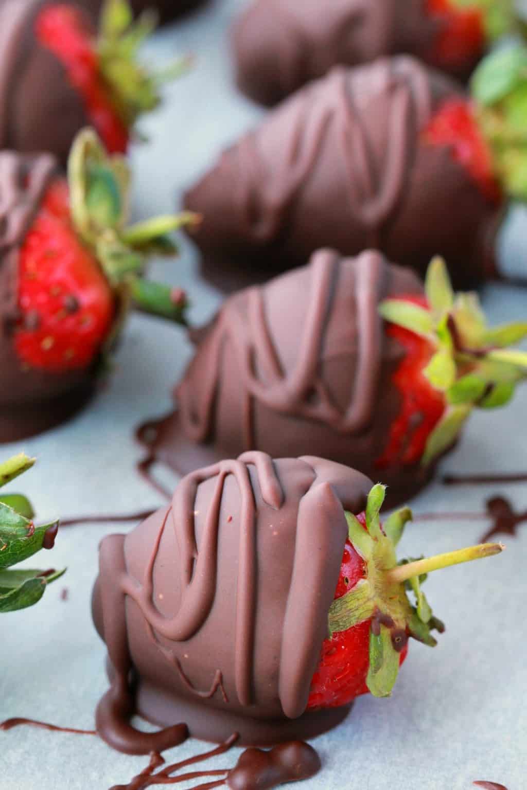 Vegan chocolade bedekte aardbeien op perkamentpapier. 