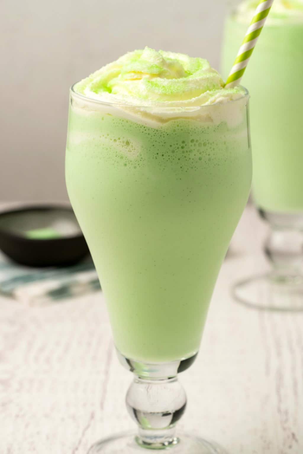 Vegan shamrock shake topped with whipped cream and green sanding sugar. 