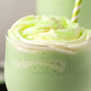 Vegan shamrock shakes topped with vegan whipped cream and green sanding sugar.
