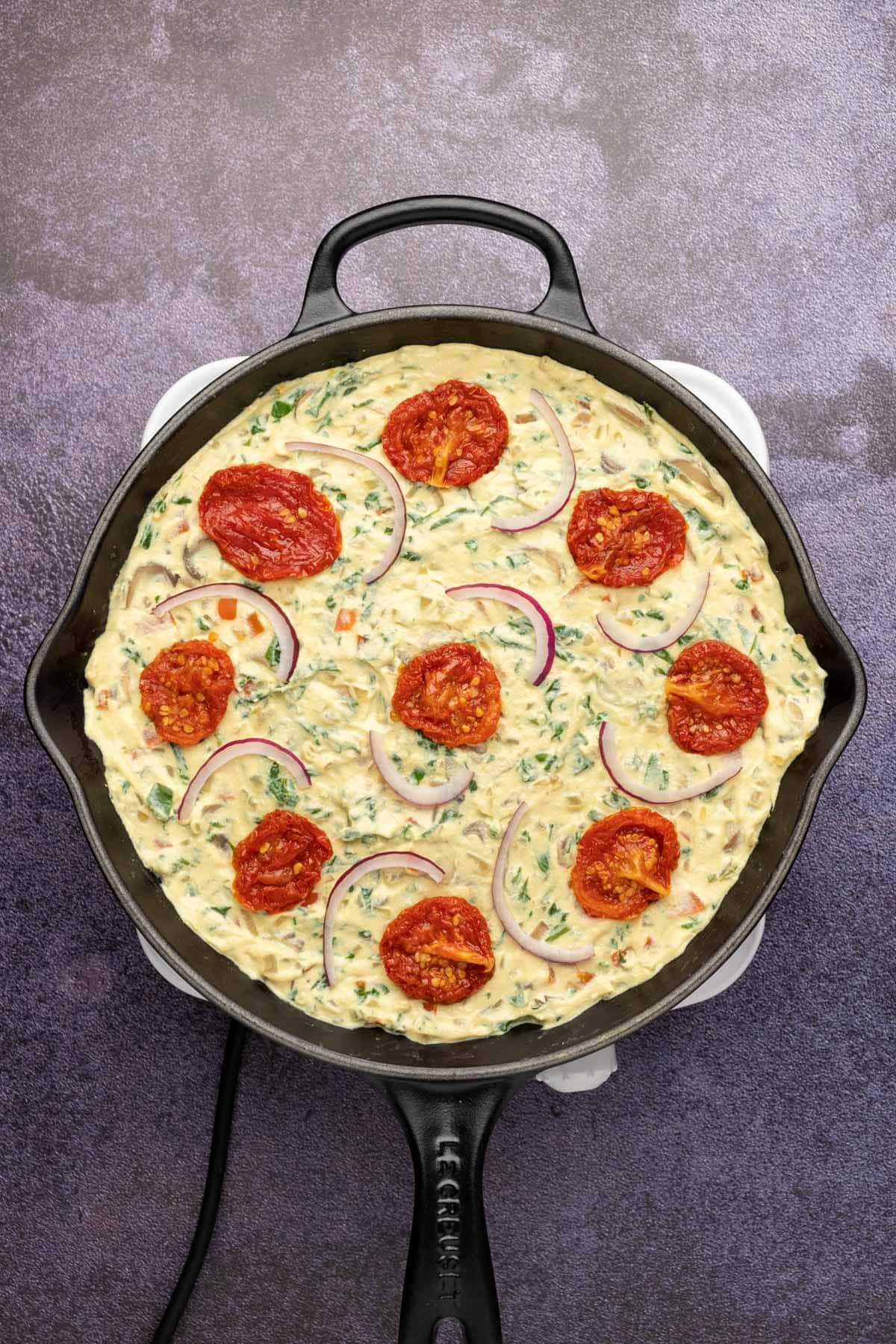 Vegan frittata in a cast iron skillet ready to bake.