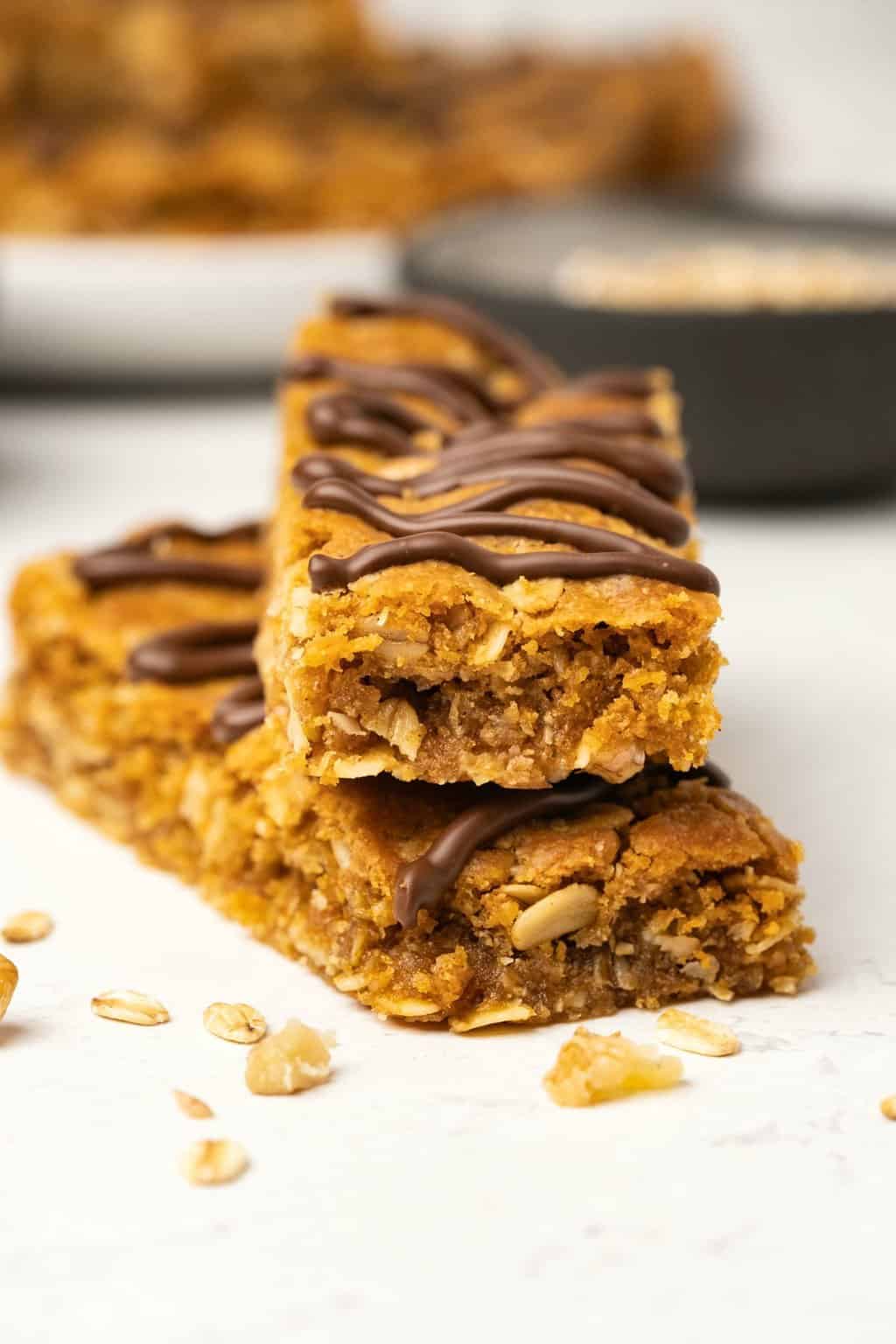 Vegan oatmeal bars topped with drizzled chocolate. 