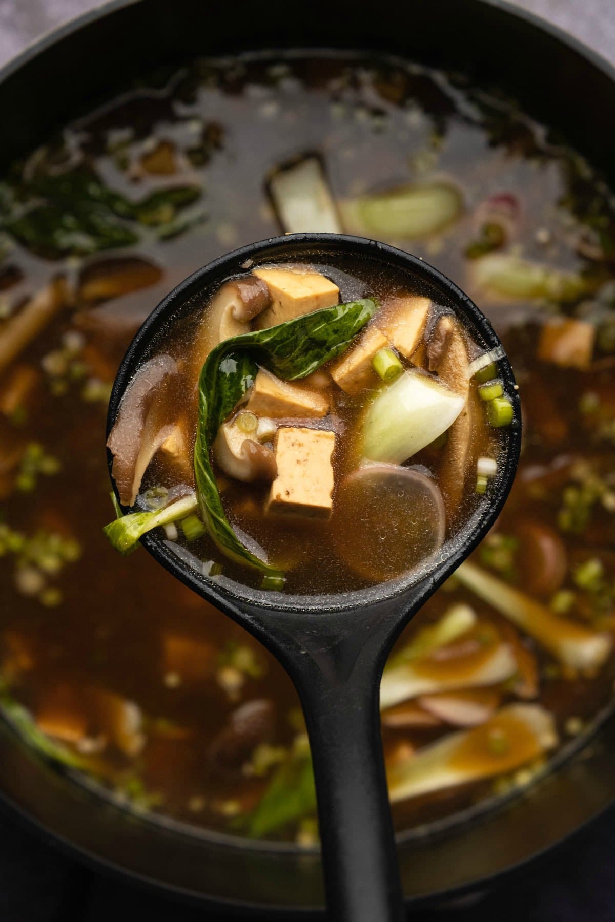 Veggie broth for ramen in a pot with a ladle.