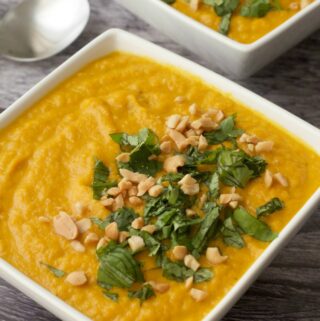 Vegan carrot soup in white bowls.