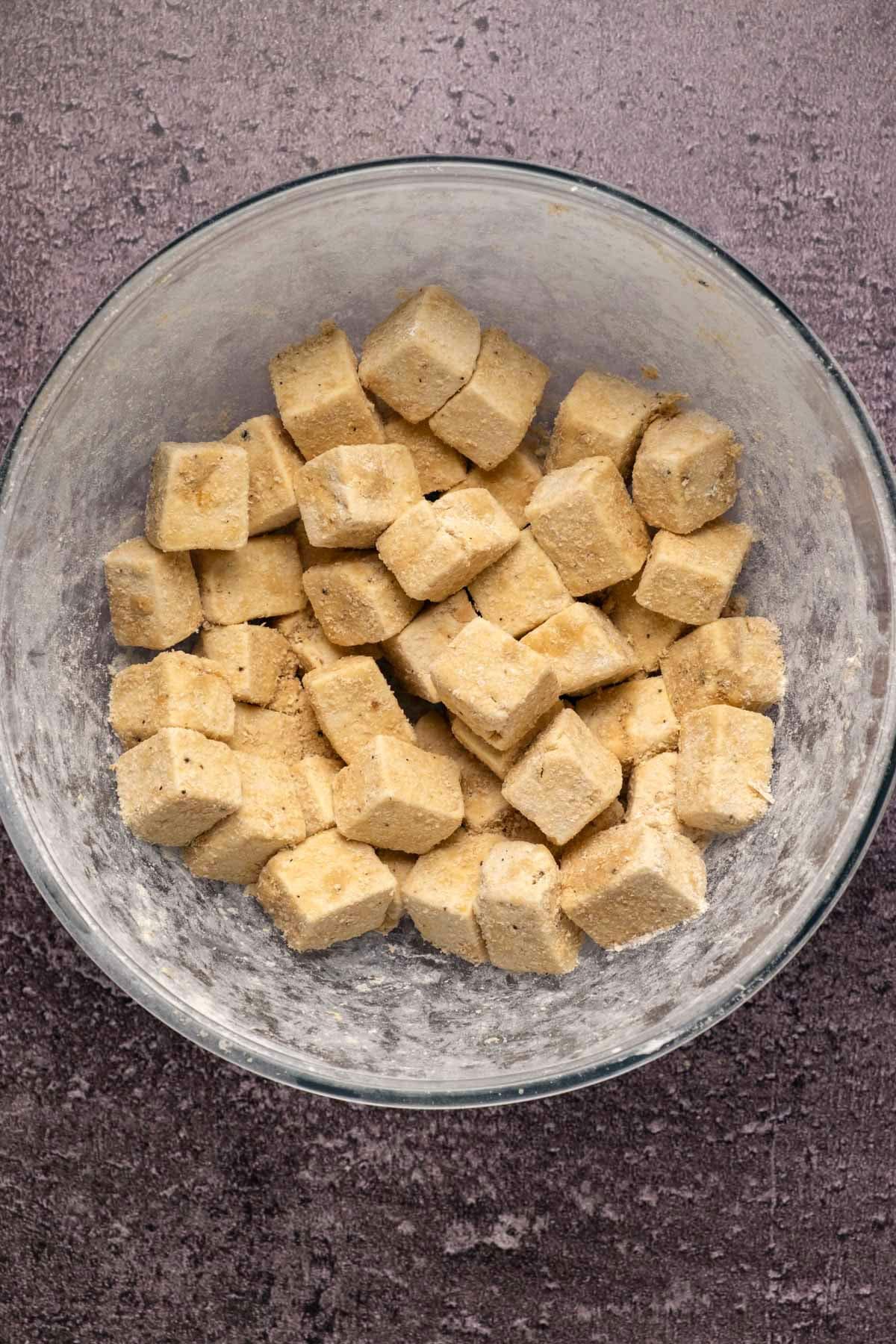 Tofu and spices in a mixing bowl.