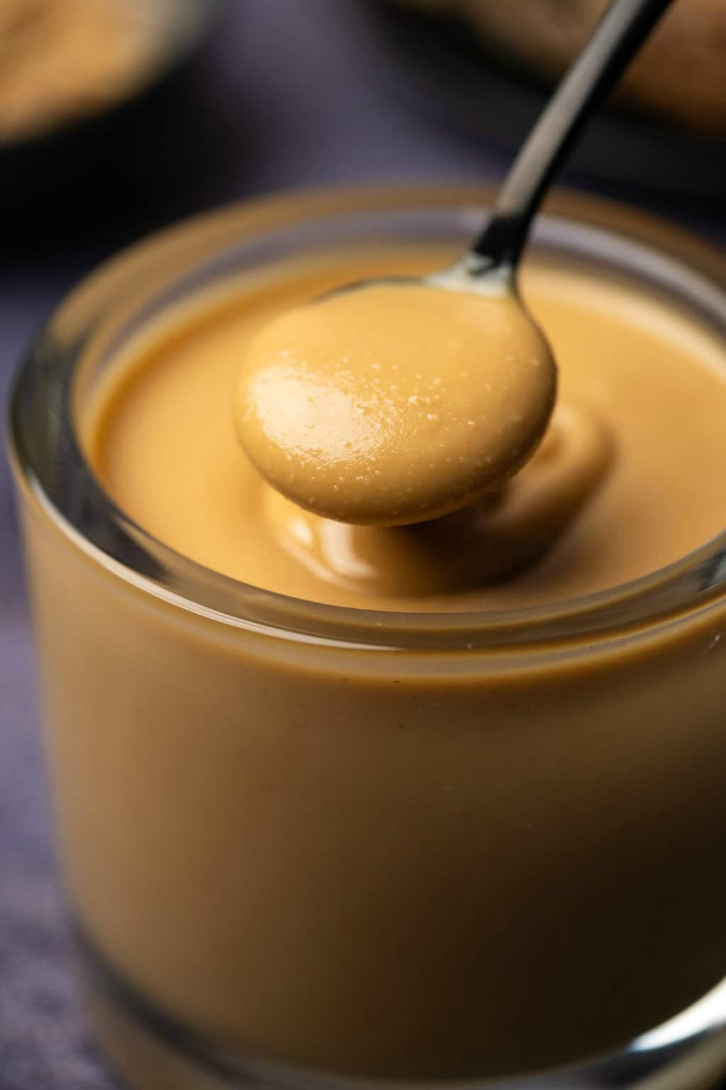 Glass jar of peanut butter with a spoon. 