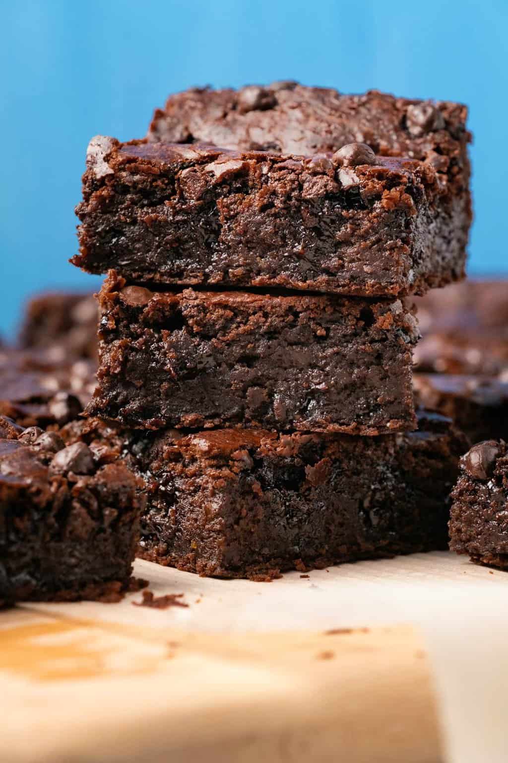 Black bean brownies stacked up on a wooden board. 