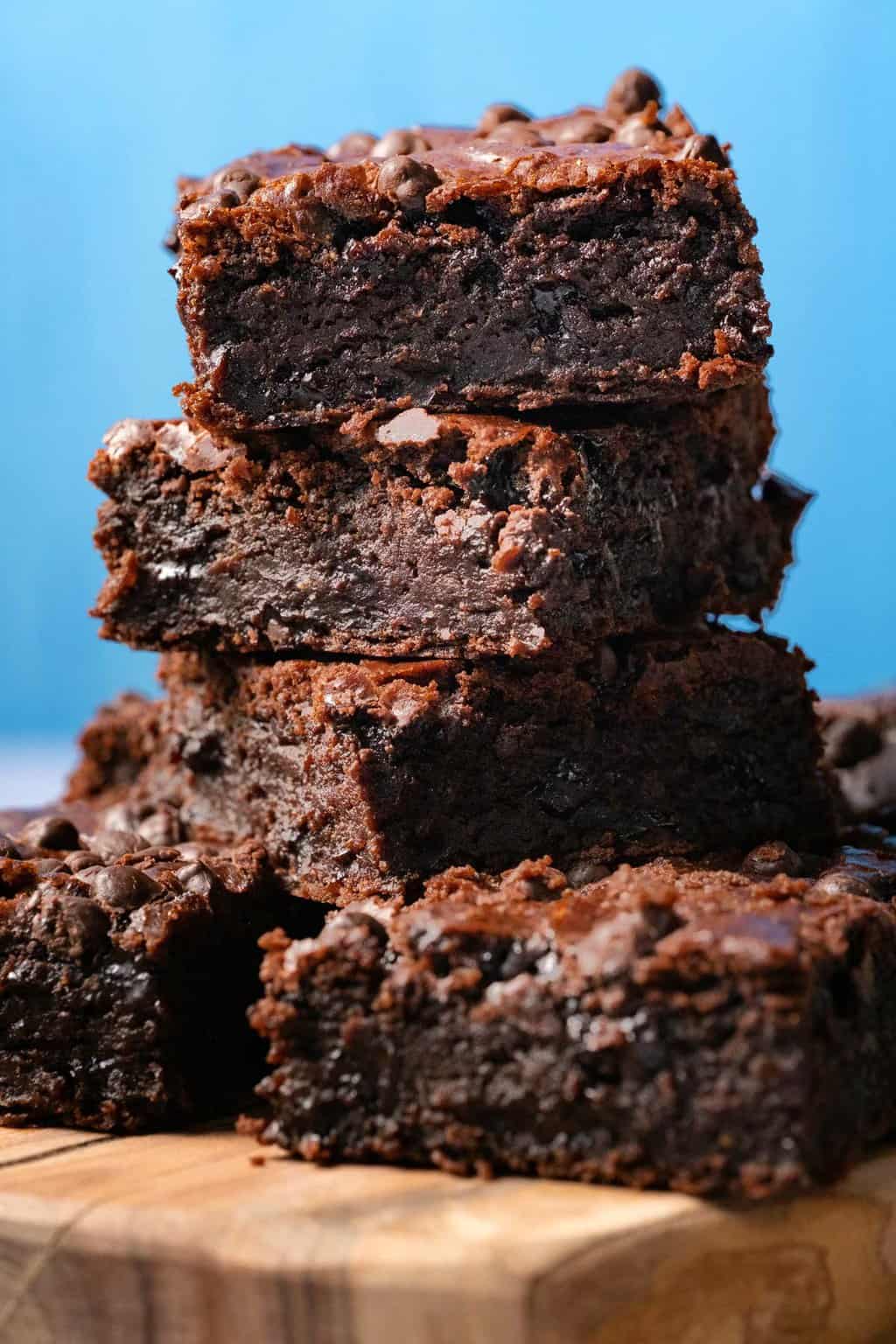 A stack of black bean brownies on a wooden board. 