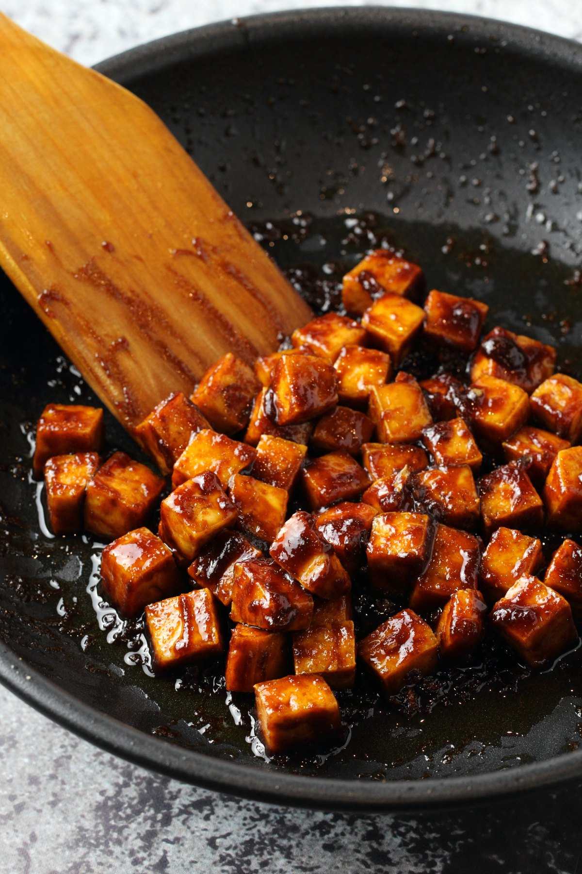 Fried tofu and sauce in a pan.