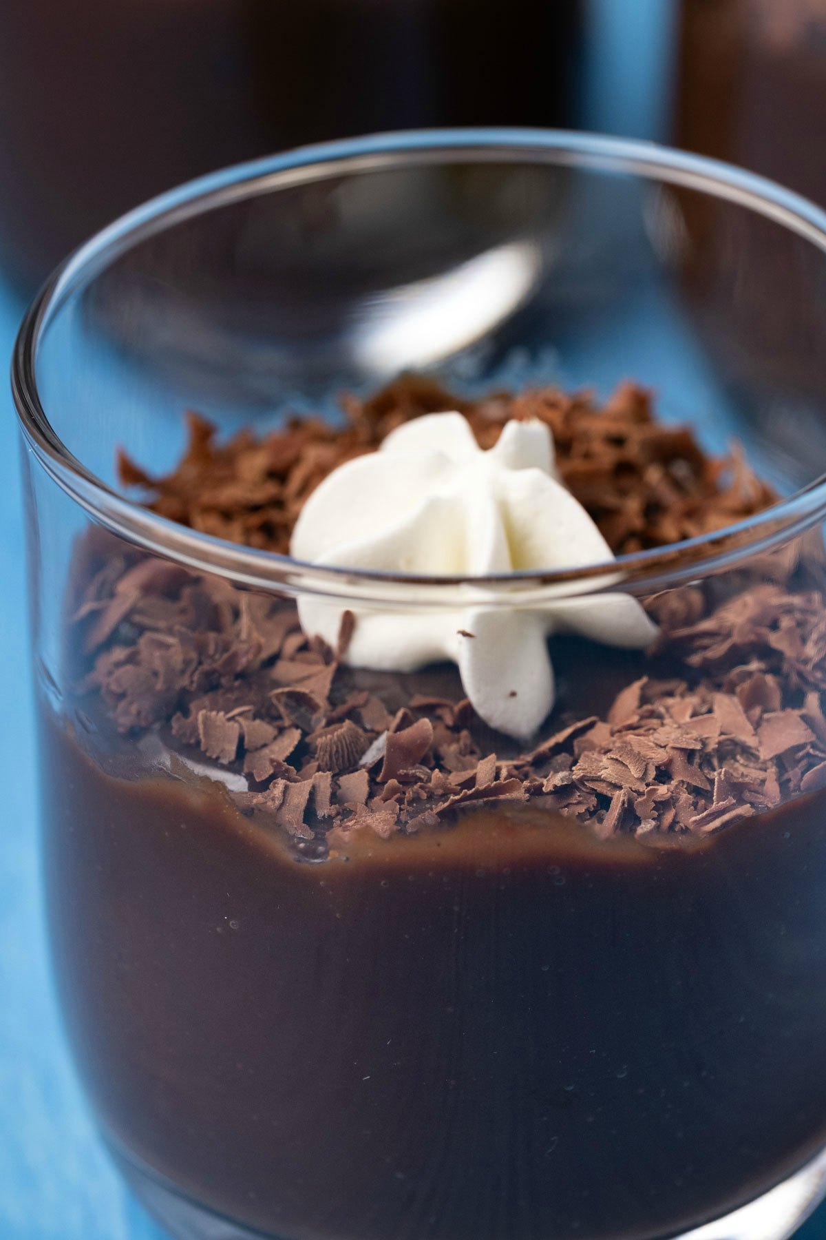 Glass of chocolate pudding with whipped cream and chocolate shavings. 