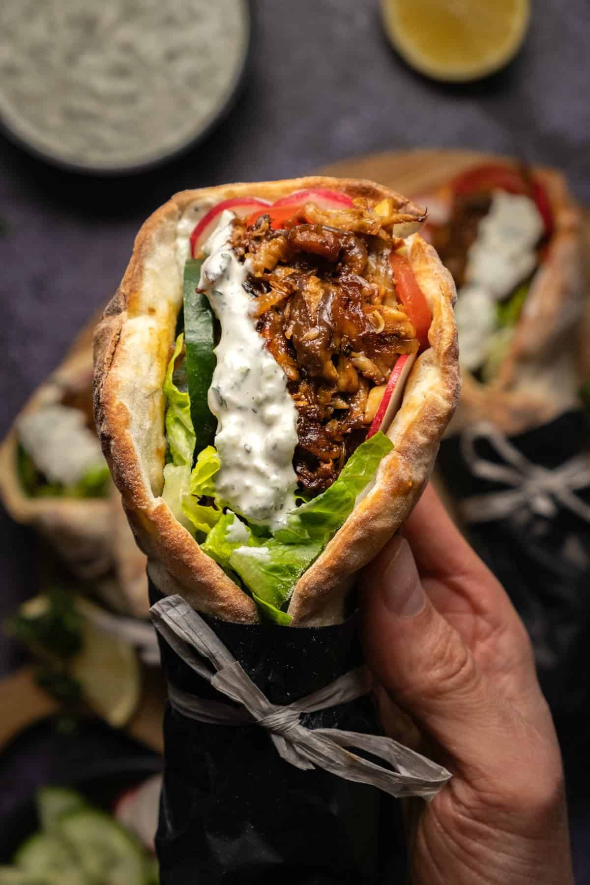 A hand holding a gyro. 