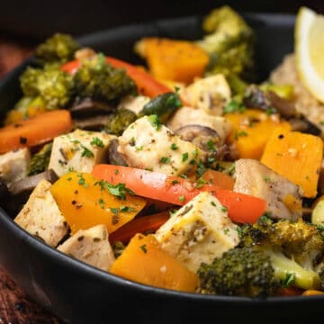 Vegetable casserole in a black bowl with quinoa.