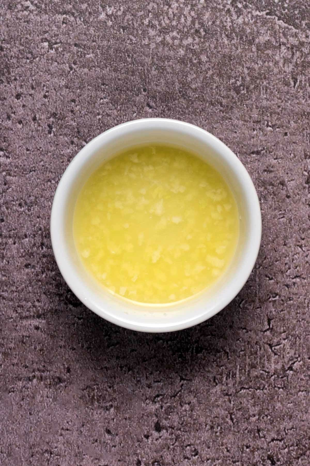 Fresh garlic soaking in a bowl of fresh lemon juice.