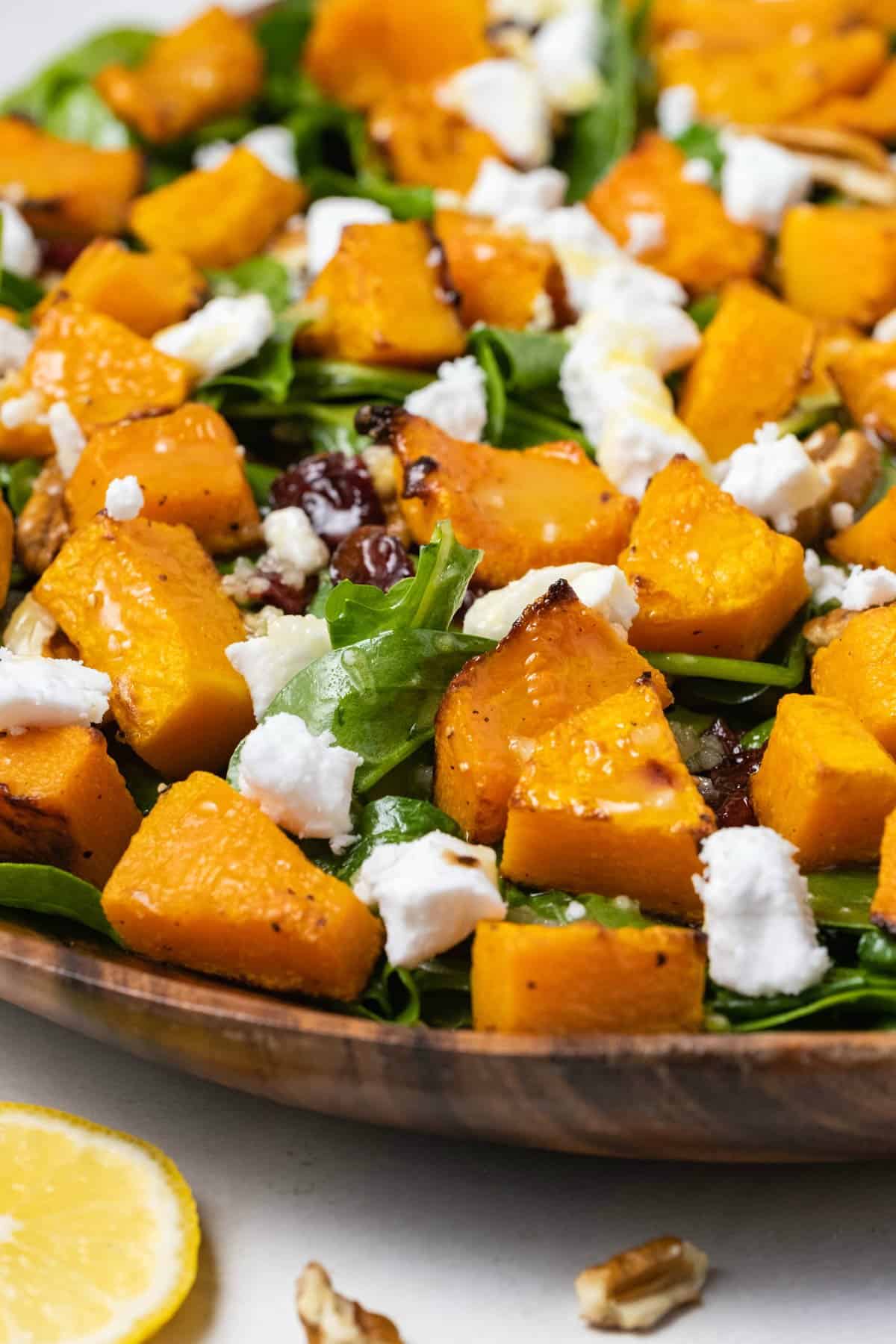 Roasted butternut squash salad in a wooden serving dish. 