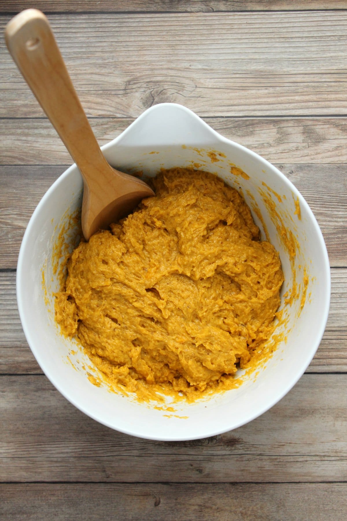 Batter for pumpkin bread in a white mixing bowl. 