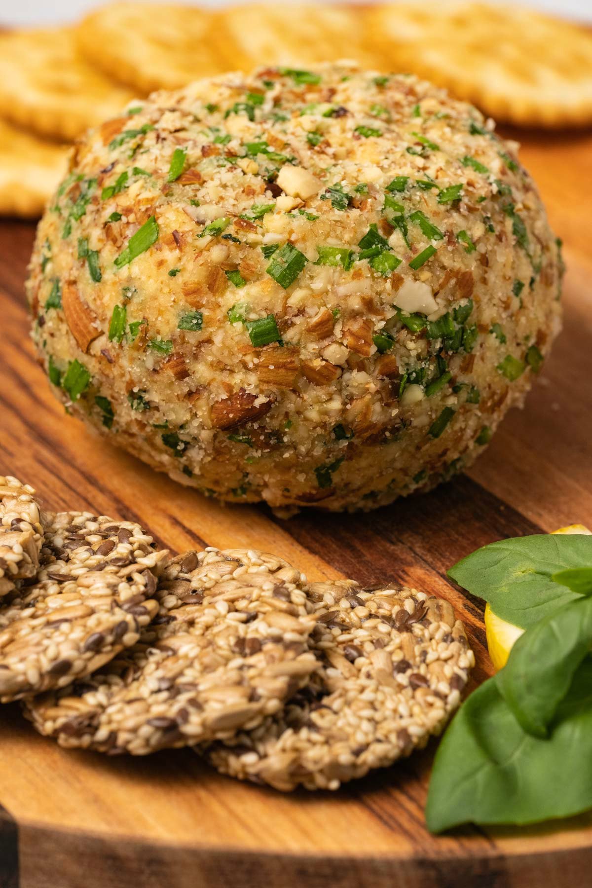 Vegan cheese ball on a wooden board with crackers. 